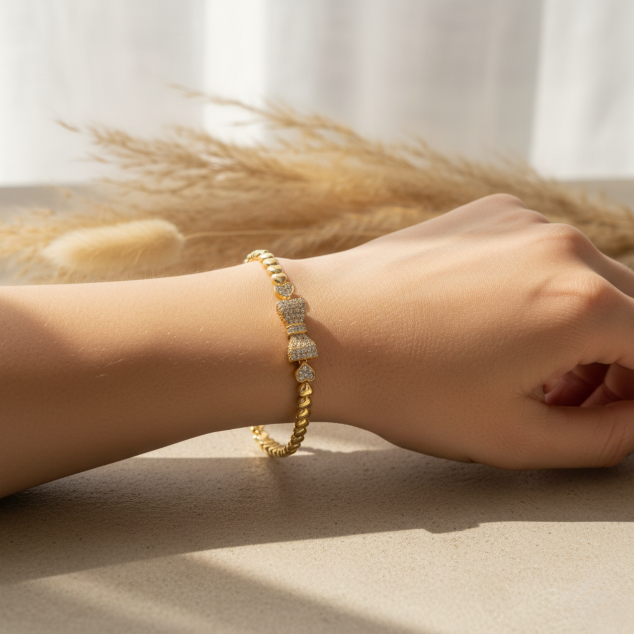 Pulsera de Corazones con Moño de Acero Enchapado en Oro de 18K