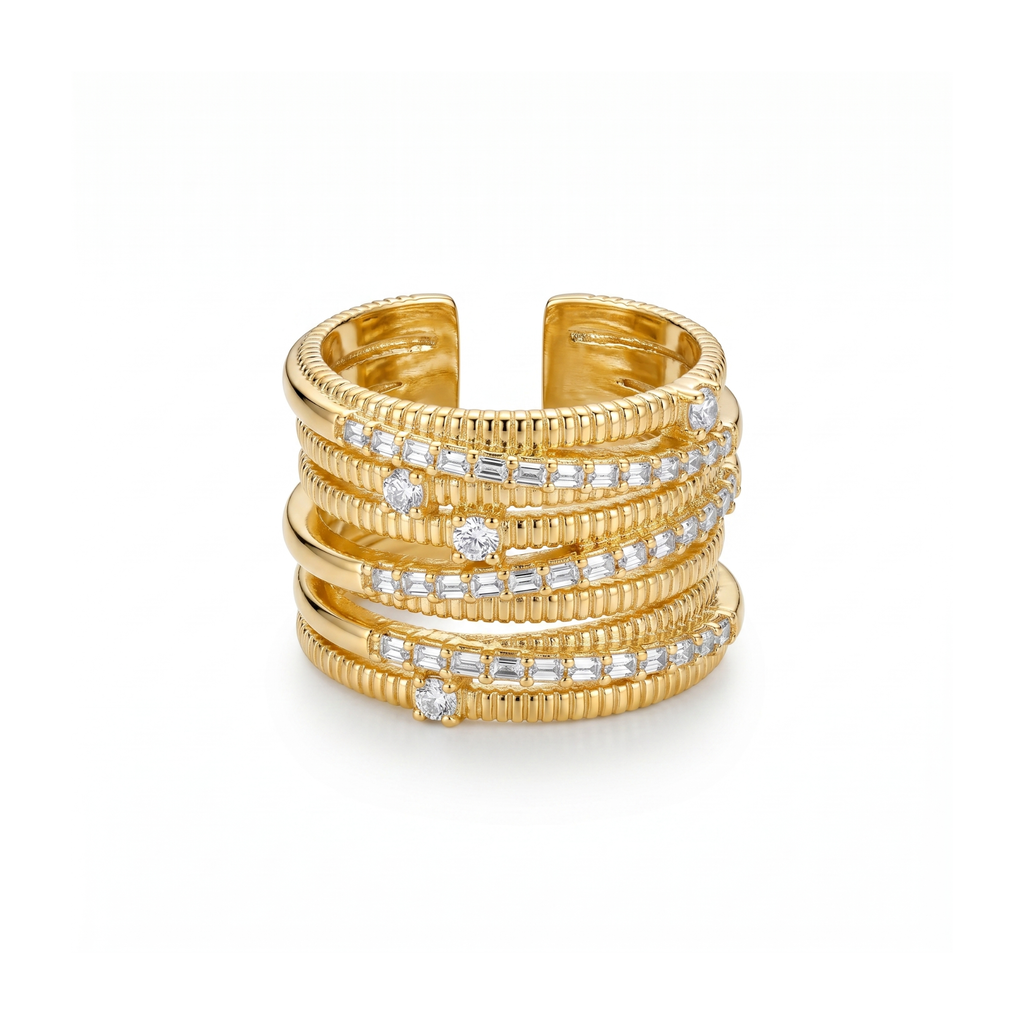 Anillo ancho y ajustable para mujer en 100% acero con baño de oro 18K. Diseño multicapa efecto apilado con texturas estriadas y piedras transparentes de talla redonda y baguette. Fabricado en Bélgica.