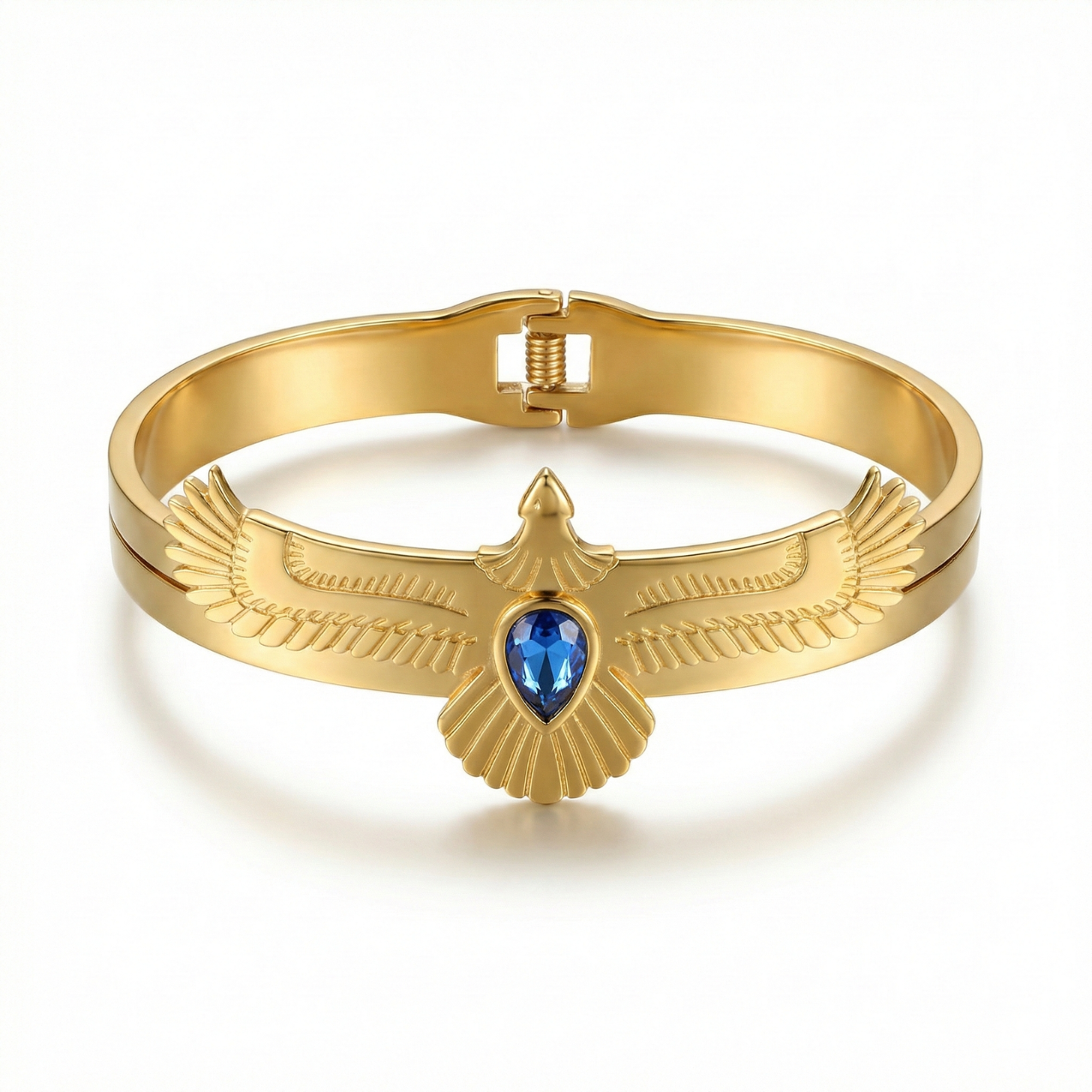Brazalete rígido de acero bañado en oro de 18K con diseño de ave de alas extendidas y piedra central azul, fabricado en España.