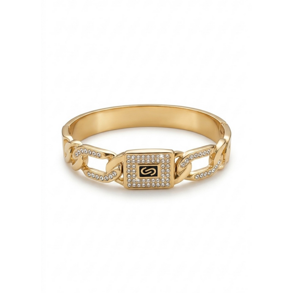 Brazalete rígido dorado de eslabones con placa central rectangular de circonitas y monograma letra S[cite: 26], con laminado en oro premium 18K PVD hecho en España.