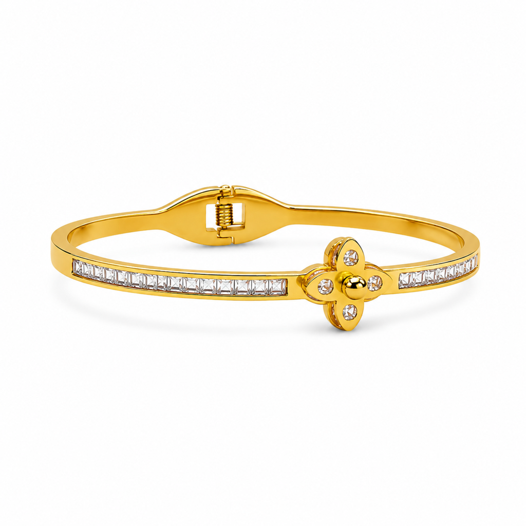 Brazalete rígido de acero bañado en oro de 18K con motivo floral estilo trébol de cuatro pétalos y banda pavimentada con circonitas brillantes.