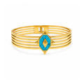 Brazalete rígido multilínea de acero bañado en oro de 18K con pieza central geométrica en forma de rombo de piedra turquesa y grabado central.