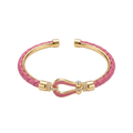 Brazalete rígido trenzado en color rosa fucsia con detalles bañados en oro de 18K y cierre decorativo con circonitas. Joyería artesanal fabricada en España.