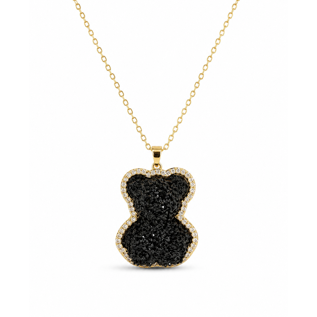 Collar de cadena con colgante en forma de oso con incrustaciones de cristales negros y borde circundado de circonitas doradas bañadas en oro de 18K.