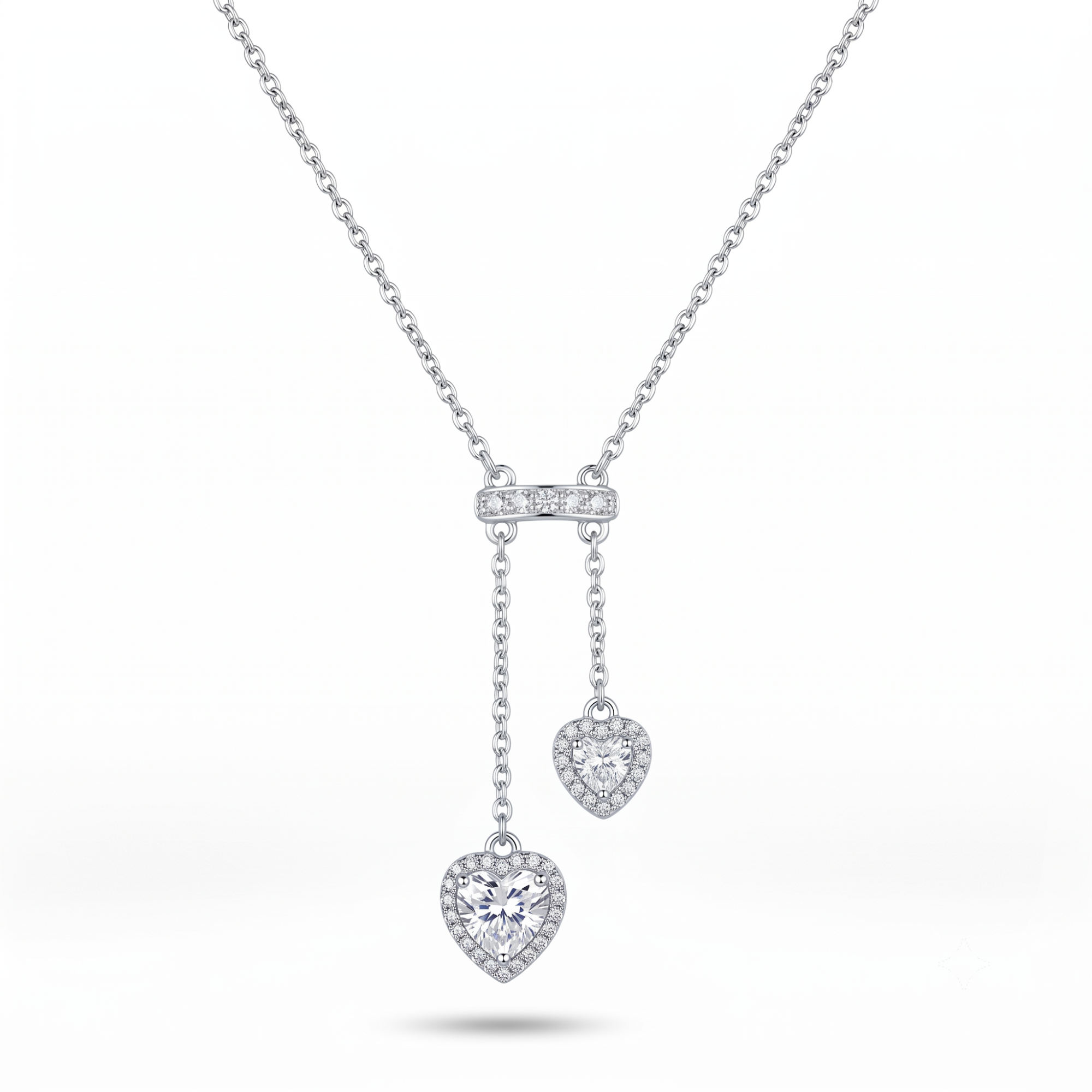 Collar estilo corbatero de acero inoxidable con baño de oro blanco de 18k PVD y dos colgantes en forma de corazón con circones, hecho en Bélgica.