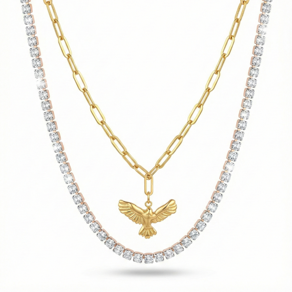 Set de collares de mujer superpuestos. Incluye una cadena tennis con brillantes y un collar de eslabones de 100% acero bañado en oro 18K con colgante de pájaro. Joyería hecha en España.