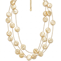 Collar de tres hilos de acero dorado con discos planos texturizados de acabado nácar crema y cierre regulable, hecho en España.