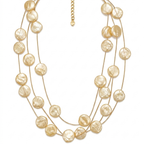 Collar de tres hilos de acero dorado con discos planos texturizados de acabado nácar crema y cierre regulable, hecho en España.