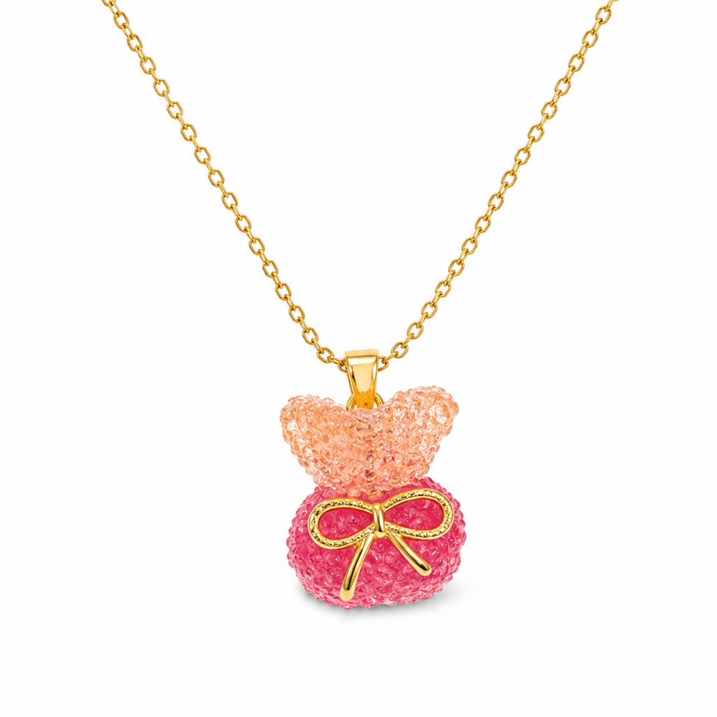 Collar de acero inoxidable bañado en oro 18k PVD con colgante de osito en resina texturizada rosa y lazo dorado hecho en España.