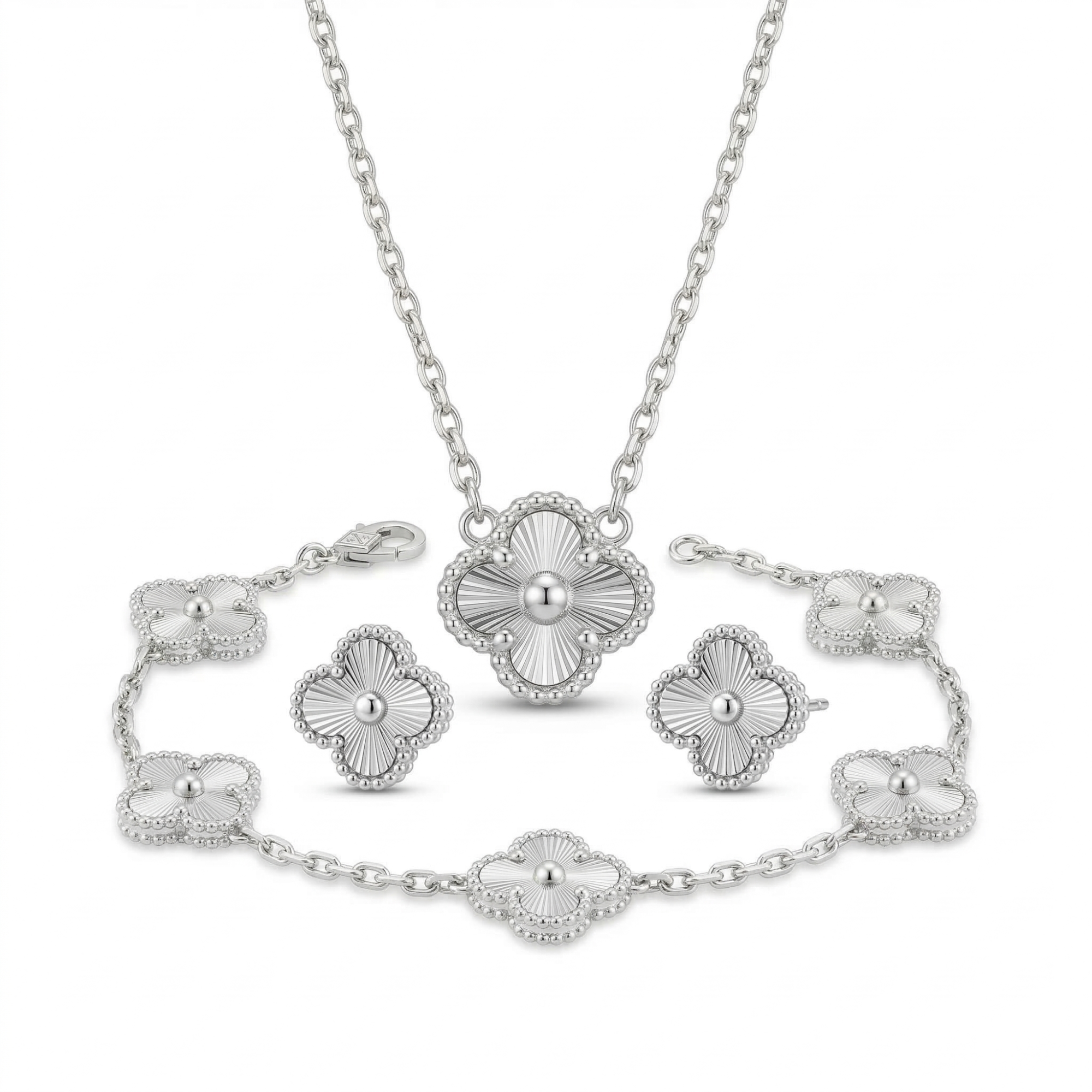 Conjunto de joyas de acero plateado que incluye collar, pulsera de cinco tréboles y pendientes con diseño de trébol grabado estilo guilloché sobre fondo blanco.