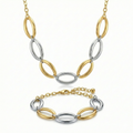 Conjunto de joyería de lujo bicolor compuesto por collar y pulsera de eslabones ovalados entrelazados. Fabricado en 100% acero inoxidable con baño de oro 18K y tono plateado. Hecho en Italia.