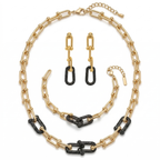 Conjunto de joyería de lujo para mujer que incluye collar, pulsera y pendientes. Diseño de eslabones modernos con detalles en pavé de cristales negros. Fabricado en 100% acero inoxidable con baño de oro 18K. Joyería exclusiva hecha en Italia.