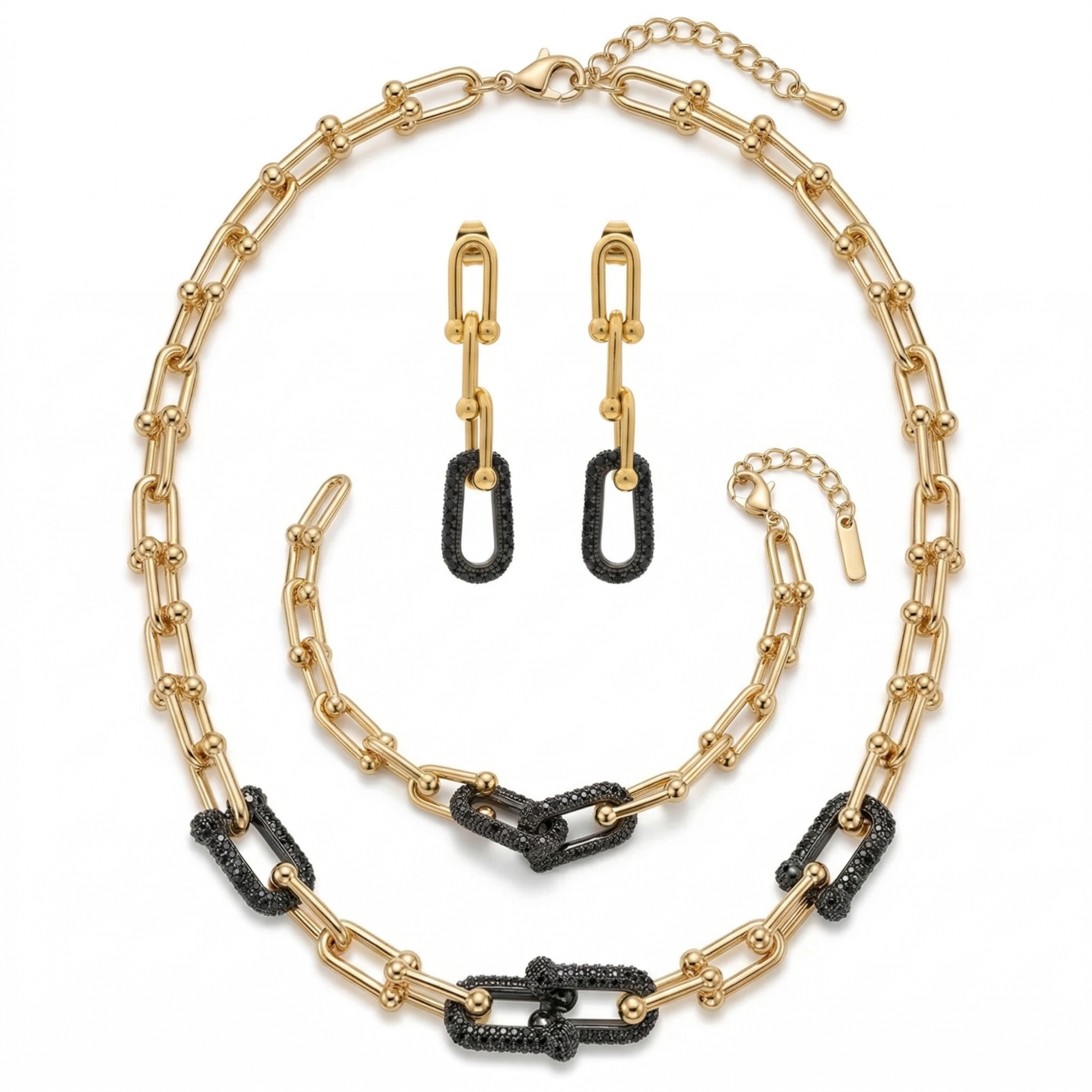 Conjunto de joyería de lujo para mujer que incluye collar, pulsera y pendientes. Diseño de eslabones modernos con detalles en pavé de cristales negros. Fabricado en 100% acero inoxidable con baño de oro 18K. Joyería exclusiva hecha en Italia.