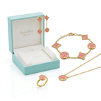 Conjunto de joyería de lujo Papelito Joyería compuesto por collar, pulsera, anillo y pendientes. Diseño de motivos florales en esmalte rosa pastel, fabricado en 100% acero inoxidable con baño de oro 18K. Hecho en Francia, presentado en caja de regalo azul.