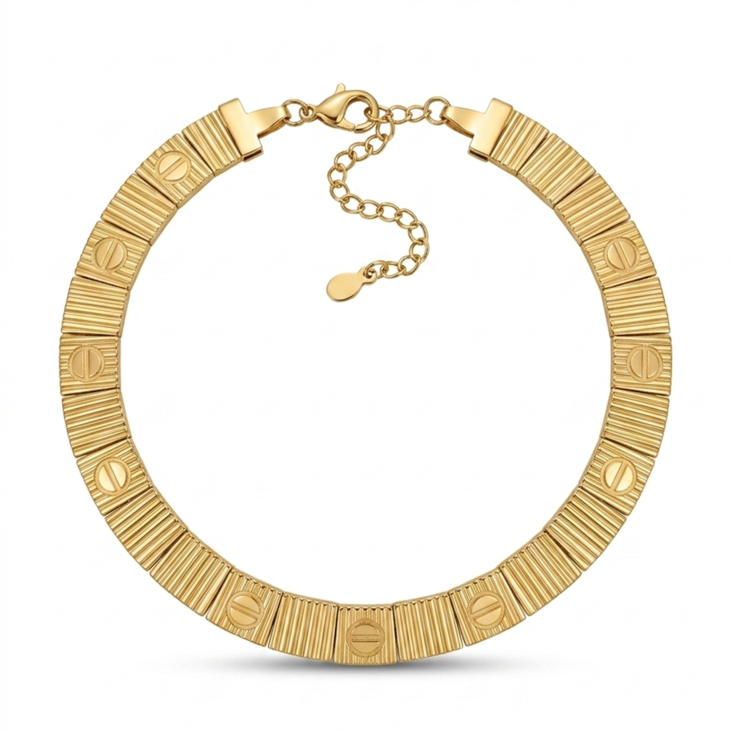 Gargantilla rígida articulada de acero con placas doradas chapada en oro de 18k, alternando texturas estriadas y motivos circulares con línea central grabada, hecha en Francia.
