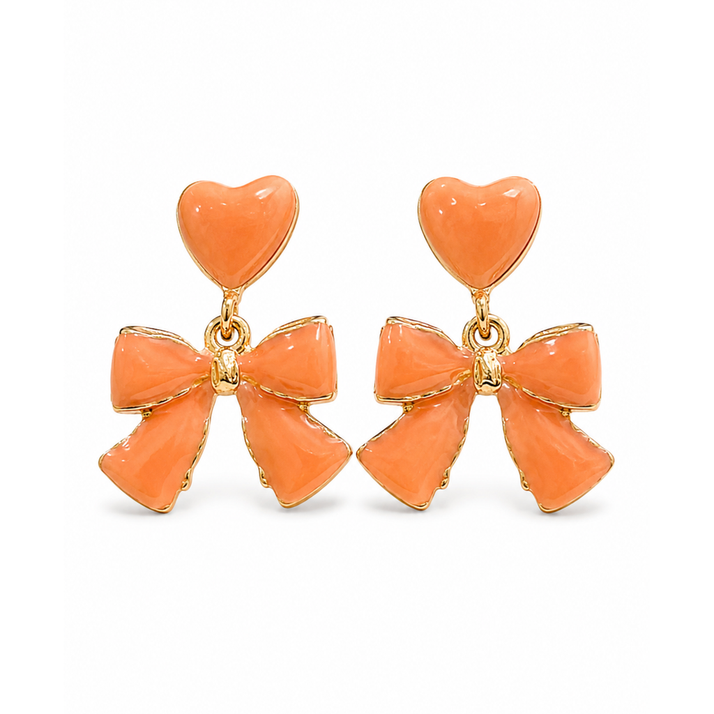 Pendientes colgantes con corazón y lazo en esmalte color melocotón de acero inoxidable con baño de oro de 18k PVD hechos en España.