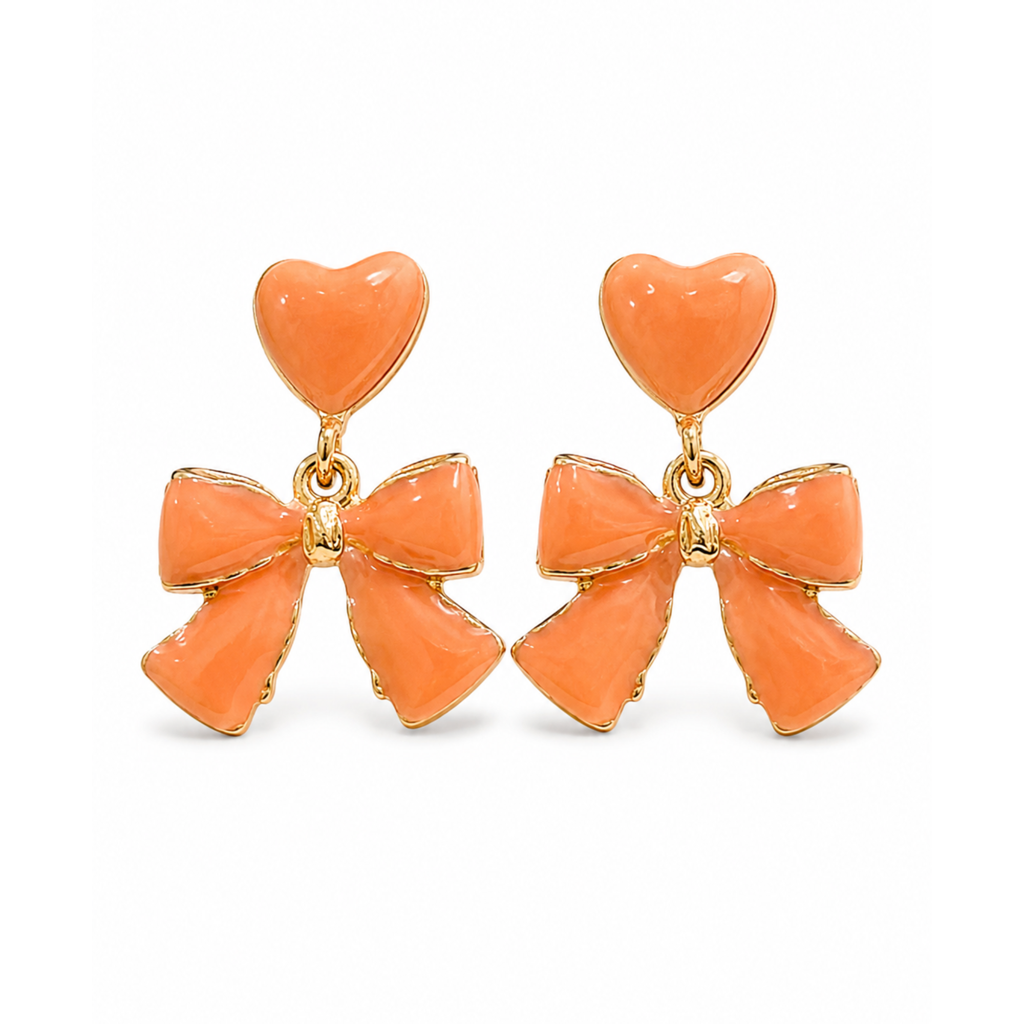 Pendientes colgantes con corazón y lazo en esmalte color melocotón de acero inoxidable con baño de oro de 18k PVD hechos en España.