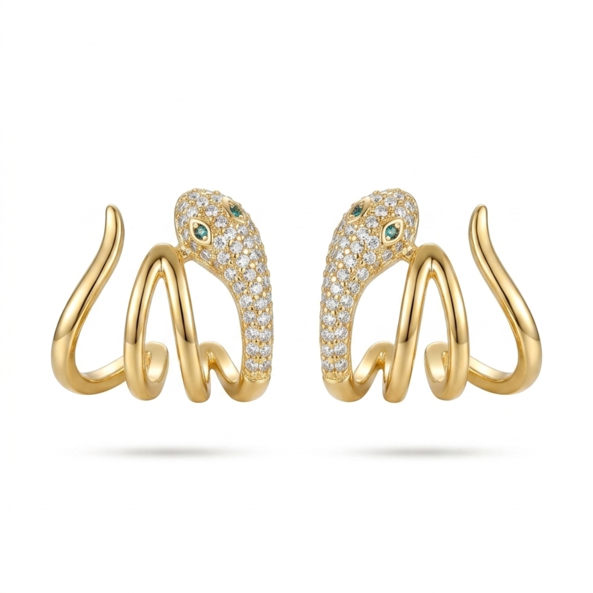 Vista frontal de pendientes de acero tipo medio aro con diseño simétrico de serpiente en oro de 18k, cuerpo de ondas lisas y cabeza brillante con pavé de circonitas y ojos verdes, hechos en Bélgica.