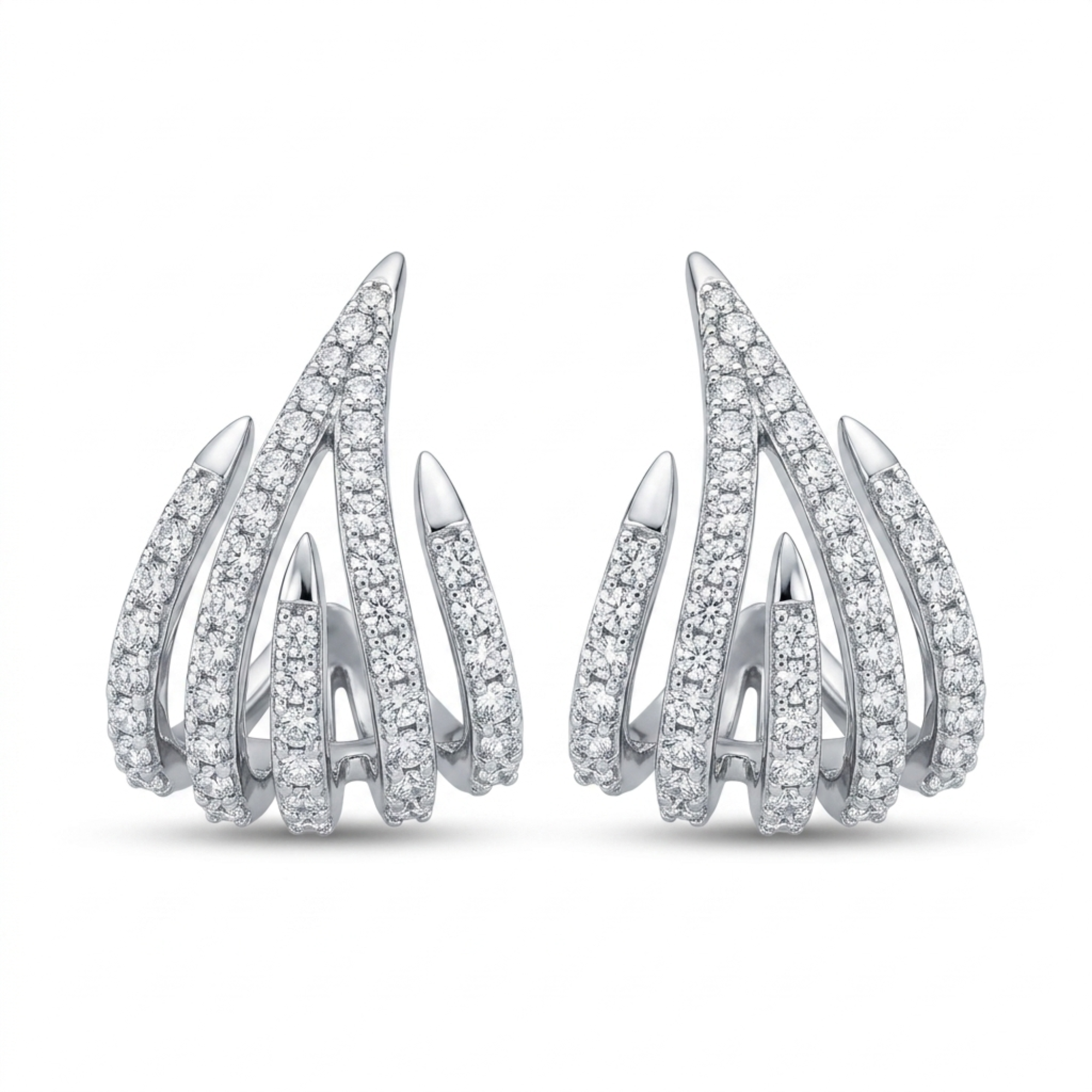 Pareja de pendientes de acero tipo garra esculpida chapados en oro blanco de 18k, con diseño de cinco bandas puntiagudas decrecientes decoradas con pavé de circonitas brillantes, hechos en España.