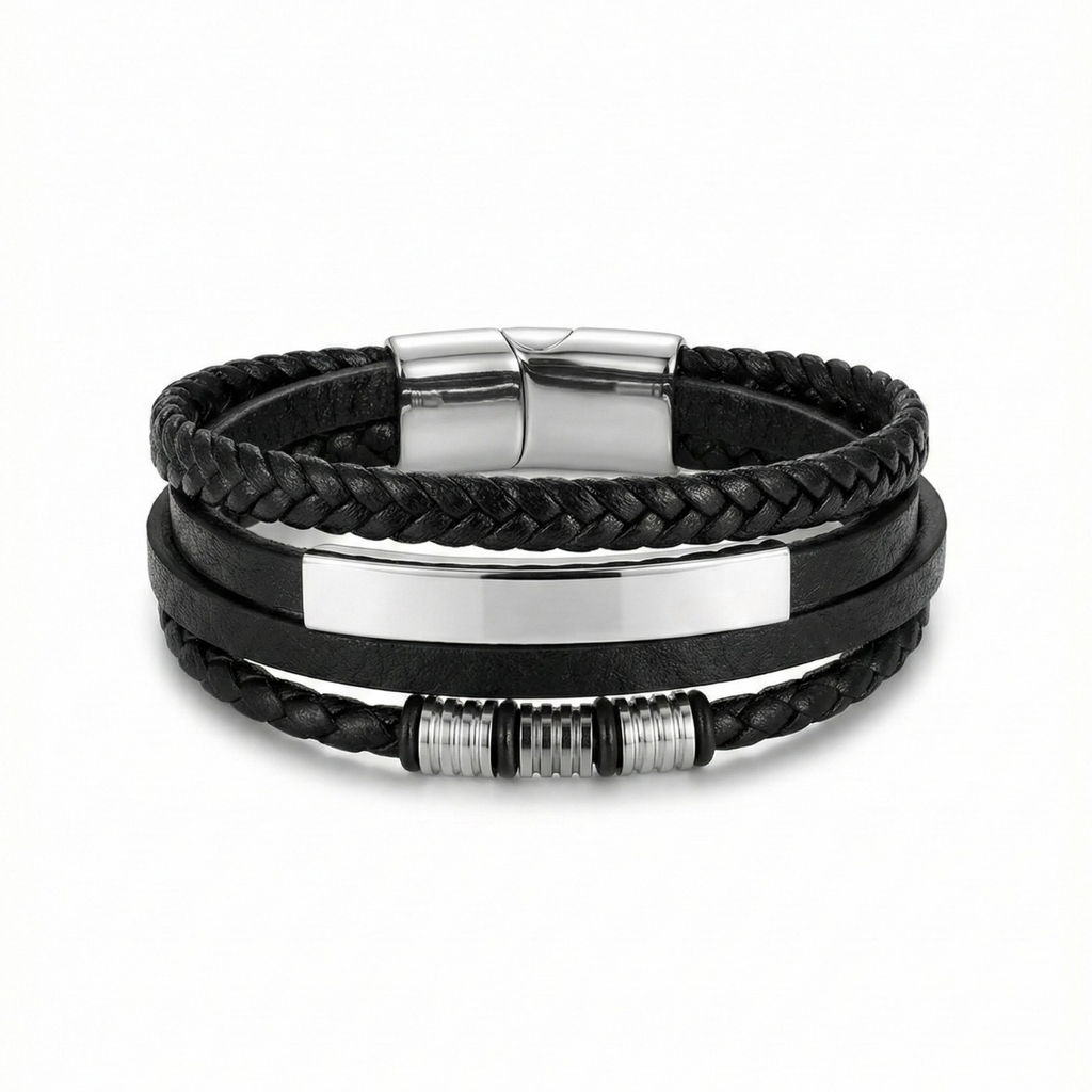 Pulsera multicapa de cuero negro trenzado para hombre con placa de acero bañada en oro de 18k y cierre magnético, fabricada en España.
