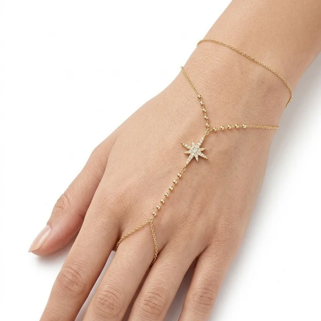 Pulsera de mano estilo hand chain bañada en oro de 18k PVD con estrella polar engastada en zirconias y esferas doradas, hecha en España.