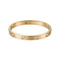 Pulsera Love rígida de acero inoxidable 100% bañada en oro de 18K (18K Gold Plated) con incrustaciones de cristales, hecha en España, sobre una mesa frente a un teclado de ordenador.