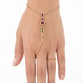 Elegante pulsera de mano con piedras geométricas en tonos amatista, rubí y esmeralda, bañada en oro de 18 quilates.