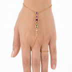 Elegante pulsera de mano con piedras geométricas en tonos amatista, rubí y esmeralda, bañada en oro de 18 quilates.