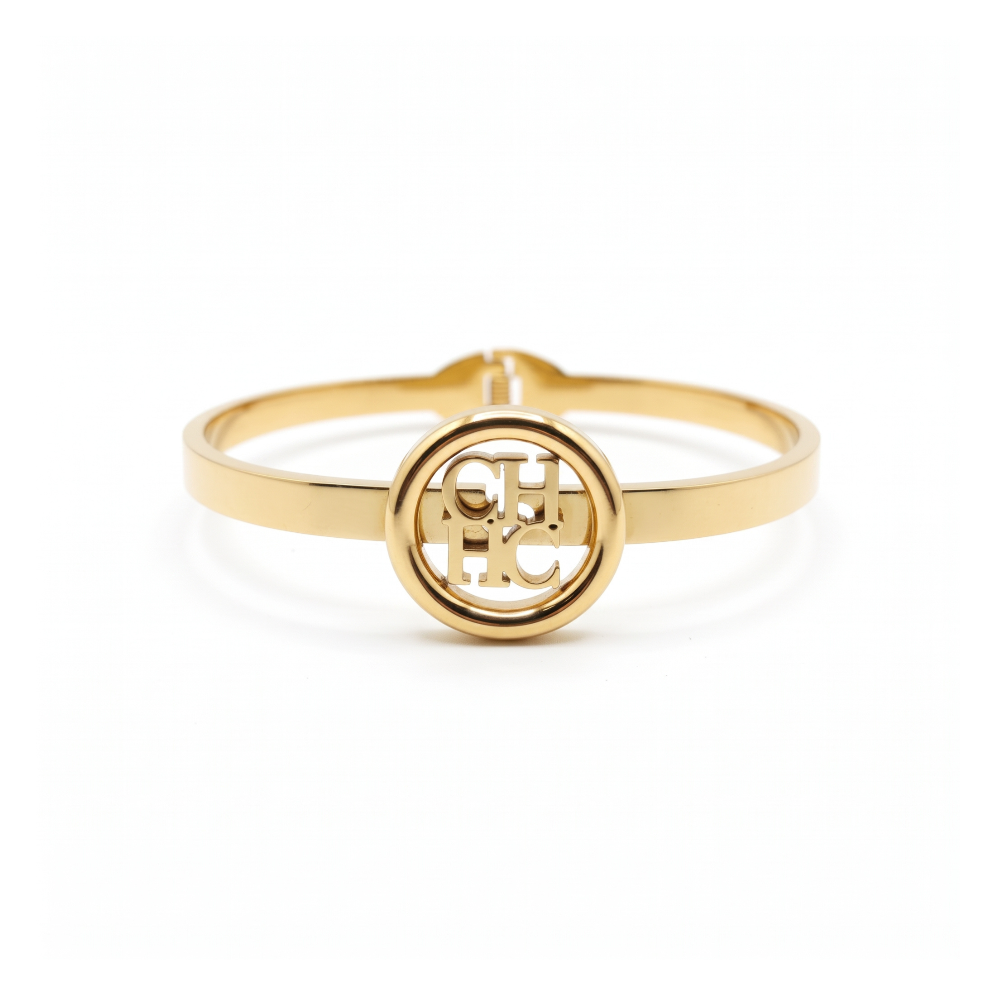 Pulsera rígida tipo bangle de acero inoxidable bañada en oro 18k con medallón central de monograma circular calado hecha en España.