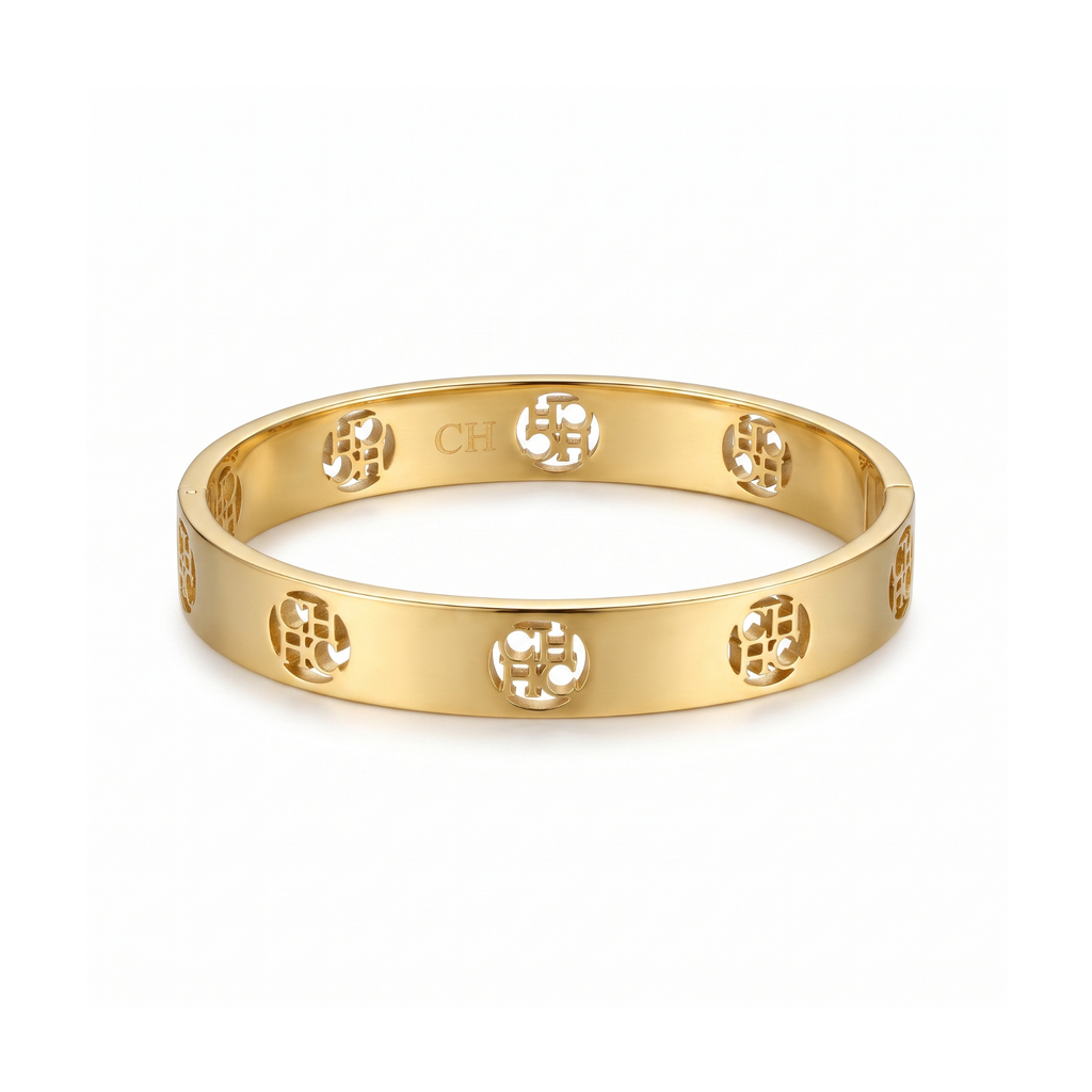 Pulsera rígida tipo bangle en acero inoxidable con baño de oro 18k y monograma circular calado hecha en España.
