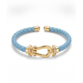 Pulsera trenzada de piel en color azul celeste con cierre estilo herradura bañado en oro de 18K y detalles de circonitas brillantes. Joyería fabricada en España.