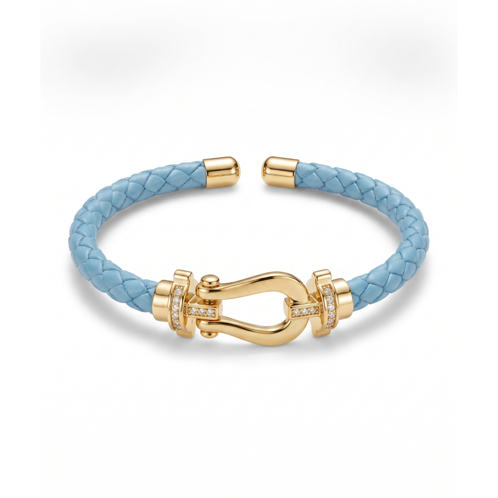 Pulsera trenzada de piel en color azul celeste con cierre estilo herradura bañado en oro de 18K y detalles de circonitas brillantes. Joyería fabricada en España.
