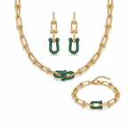 Un conjunto de joyas de lujo de acero bañado en oro de 18K, compuesto por un collar de cadena de eslabones gruesos, una pulsera a juego y un par de pendientes largos. Cada pieza tiene un diseño central de eslabones entrelazados adornados con pavé de piedras verdes brillantes, fabricado en Italia.