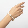 Pulsera Rígida con Trébol de Nácar y Circonitas, Detalles Esmaltados Blancos - 100% Acero Bañado en Oro 18K