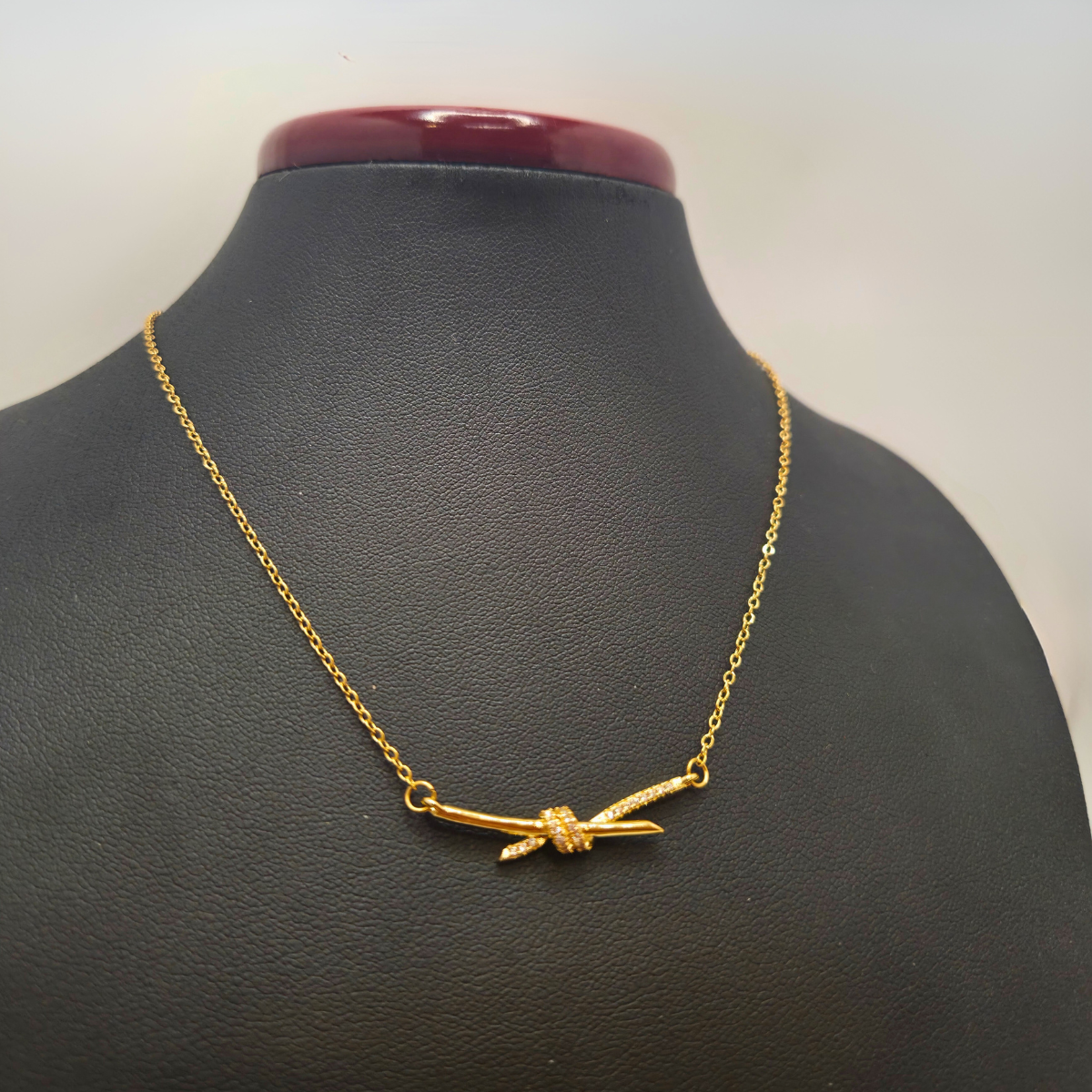 Collier en acier plaqué or 18 carats avec pendentif nœud en zircone