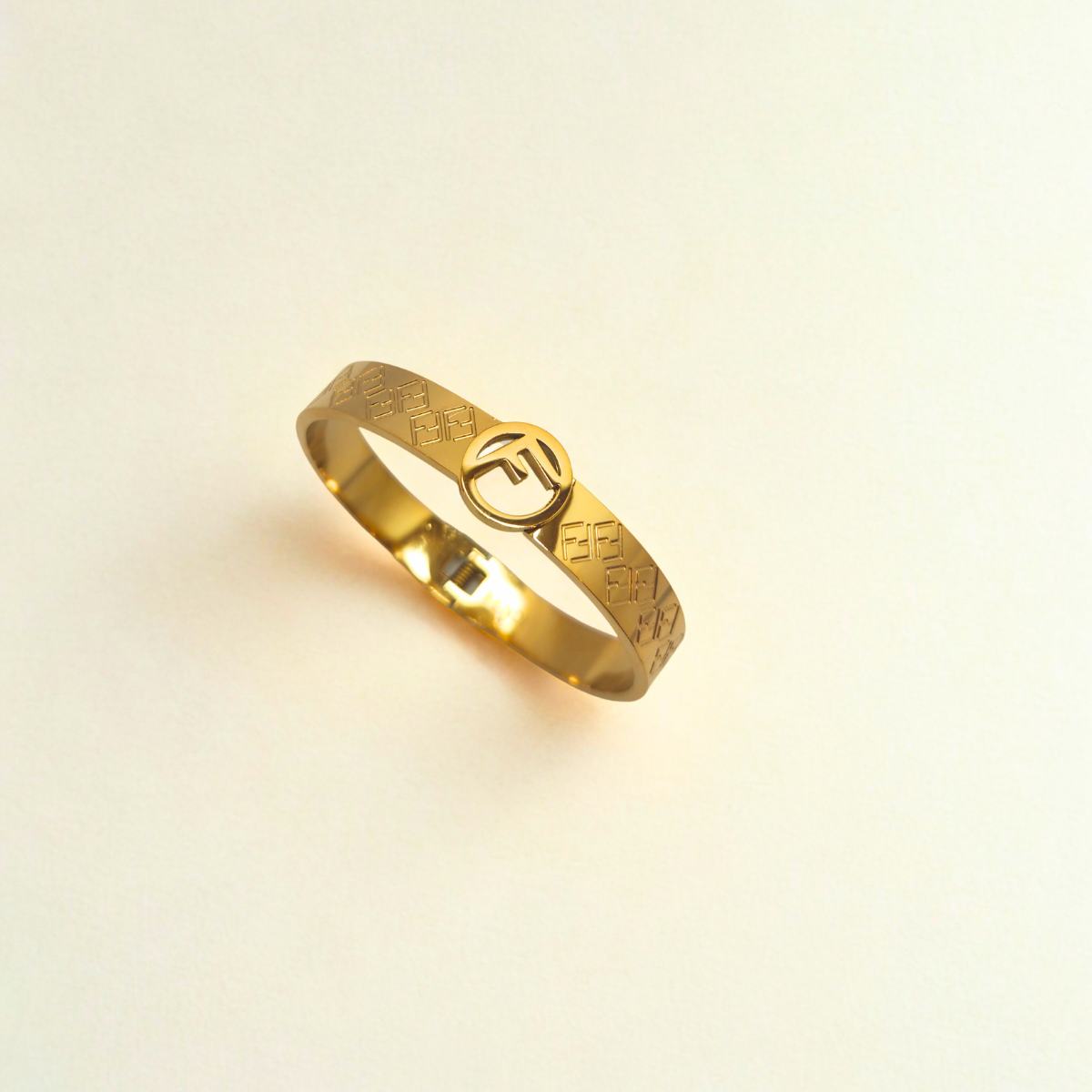 Pulsera Rígida con Patrón de Letras Entrelazadas y Círculo Central 100% Acero Bañado en Oro 18K