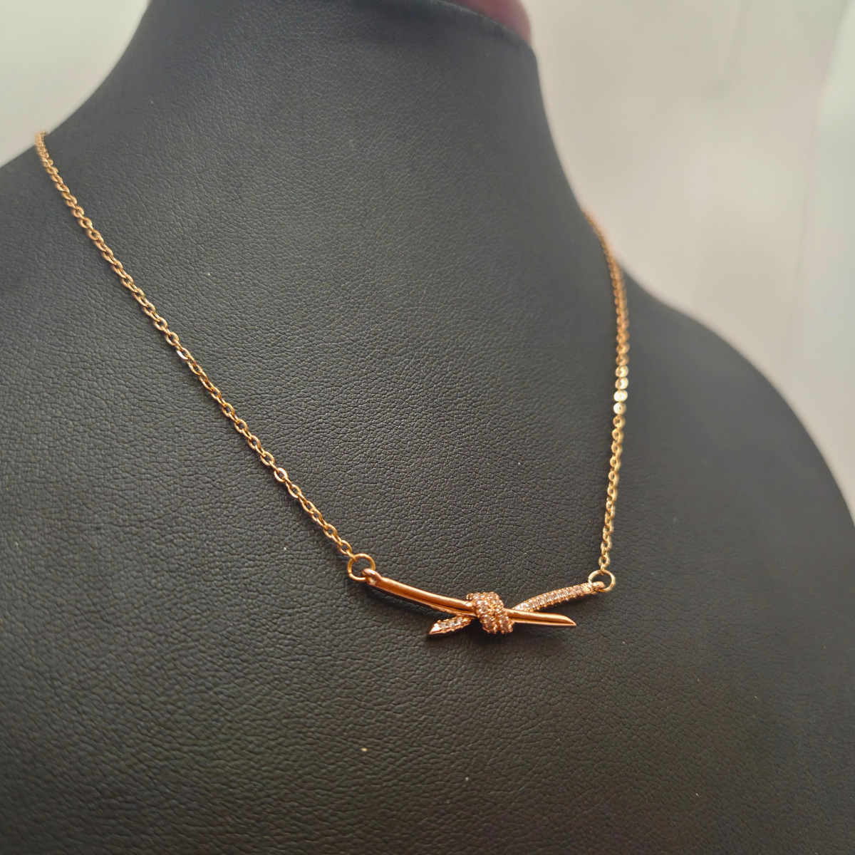 Collier en acier plaqué or rose 18 carats avec pendentif nœud en zircone