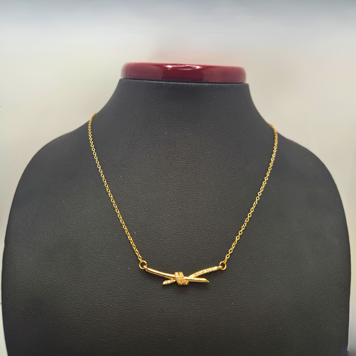 Collier en acier plaqué or 18 carats avec pendentif nœud en zircone