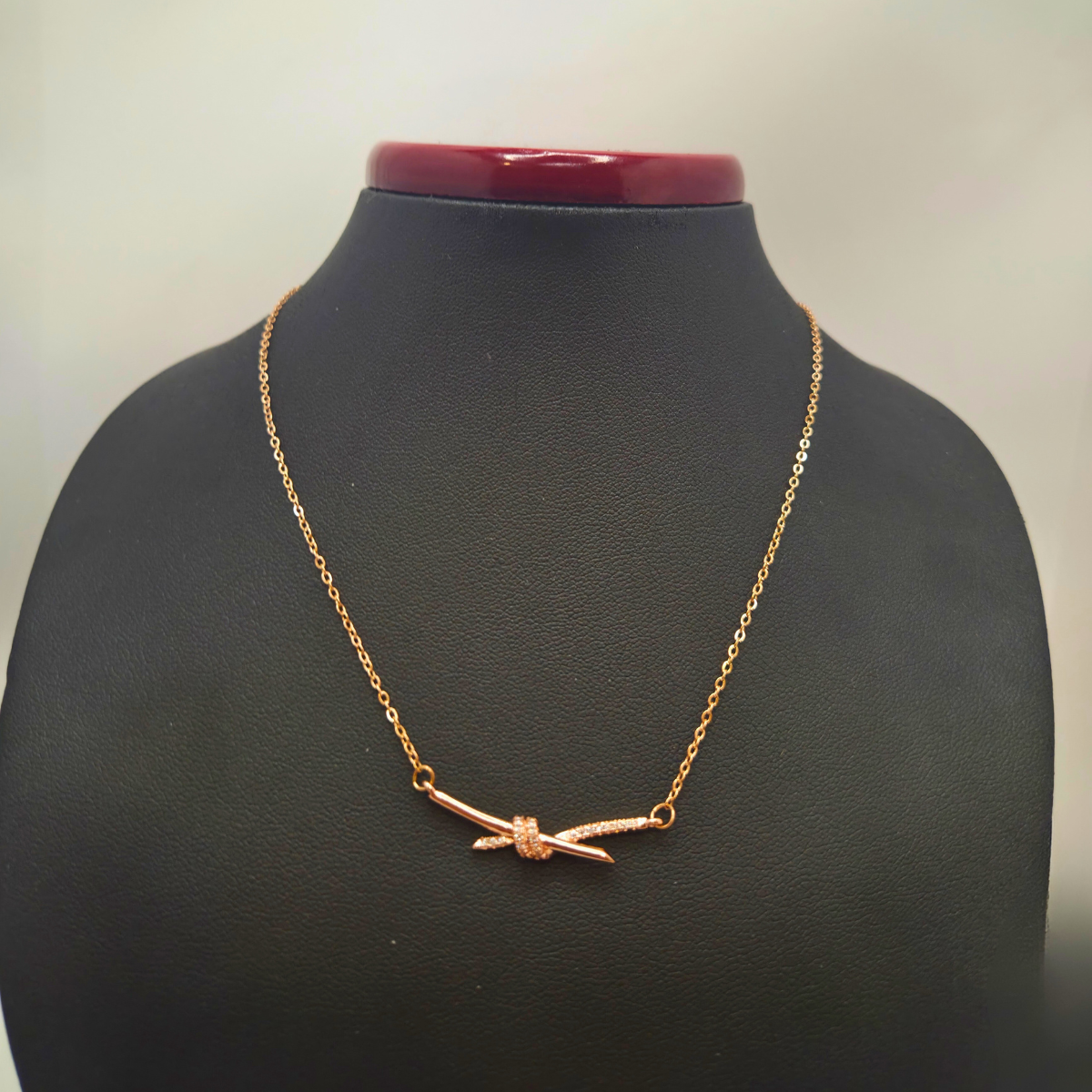 Collier en acier plaqué or rose 18 carats avec pendentif nœud en zircone