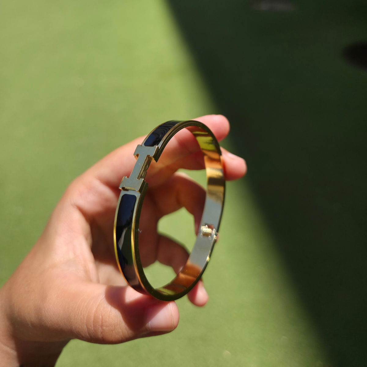 Bracelet rigide avec motif « H » et émail noir - 100 % acier plaqué or 18 carats