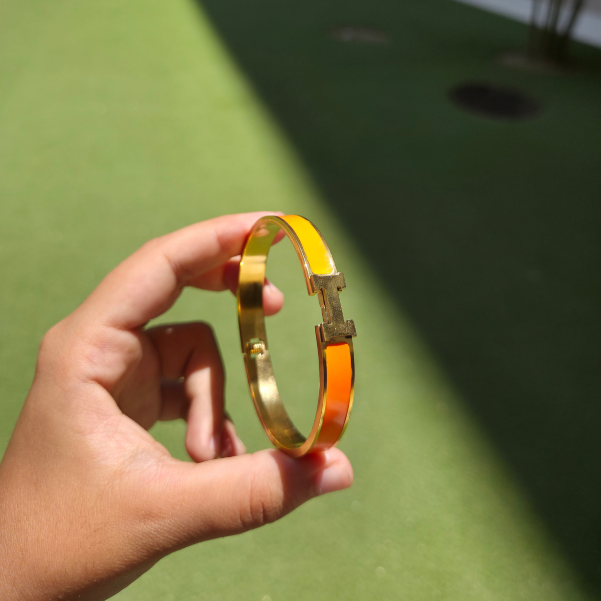 Bracelet rigide avec motif « H » et émail orange - 100 % acier plaqué or 18 carats