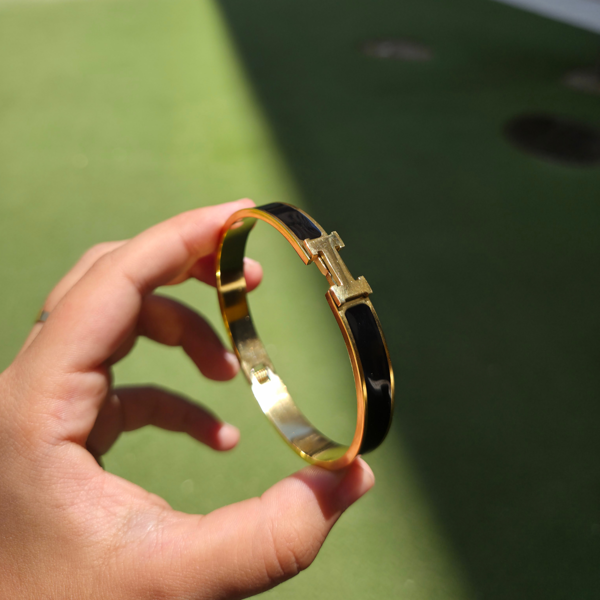 Bracelet rigide avec motif « H » et émail noir - 100 % acier plaqué or 18 carats